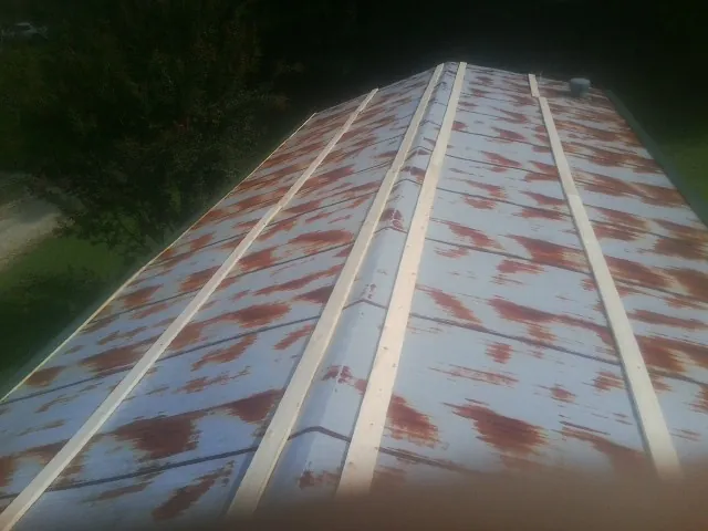 Rusted metal roof panels with new wood purlins before replacement — Storm Damage Roof Repair in Sycamore by Roofing Brothers